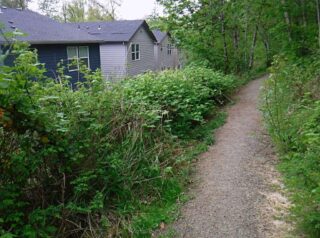 The trail starts out passing between new houses